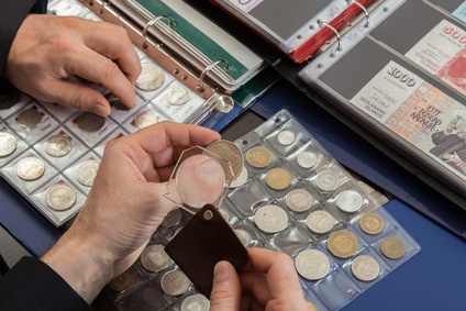 Two numismatists examines collection of coin