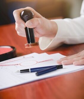 Woman Notary Public stamping the document. Law office.